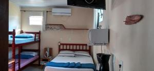 a bedroom with two bunk beds and a television at Cantinho da Família in Penha