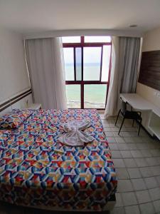 Schlafzimmer mit einem Bett, einem Schreibtisch und einem Fenster in der Unterkunft Beira Mar - Praia de Piedade - Flat Golden Beach- in Recife