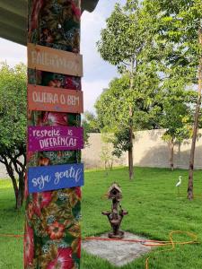 a pole with signs on it next to a fountain at Villa Flor e Cor in Cavalcante