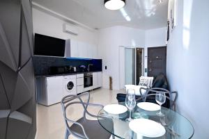 a kitchen and dining room with a table and chairs at Arcadia Promenade Grand Apartments in Odesa