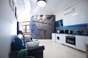 a kitchen with a couch and a stove top oven at Arcadia Promenade Grand Apartments in Odesa
