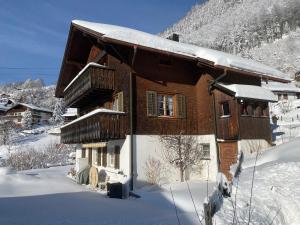 a house in the snow with snow on the roof at Gemütliche Dachwohnung im Chalet mit Bergblick in Engelberg