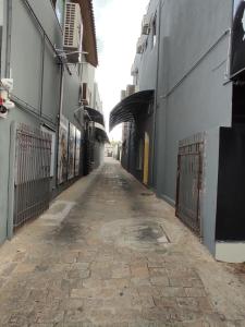 une allée vide avec un bâtiment et une clôture dans l'établissement Hotel Avenida Tupã, à Tupã