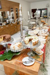 a buffet with cakes and other foods on a table at Pontal Plaza Hotel in Curvelo