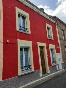 un edificio rojo y amarillo en una calle en La maison du bonheur en Fumay