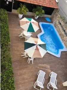una vista aérea de una piscina con sillas y sombrillas en Hotel Des Basques, en Maceió
