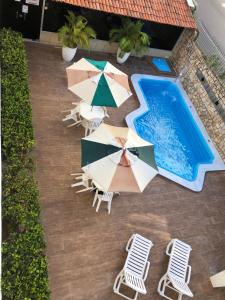 an overhead view of a pool with chairs and umbrellas at Hotel Des Basques in Maceió