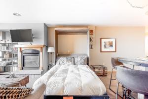 ein Schlafzimmer mit einem Bett und einem Kamin in der Unterkunft Ski In-Out Zephyr Mountain Lodge in Winter Park