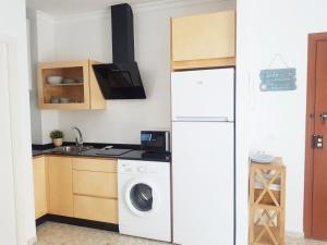 a kitchen with a washing machine and a sink at Conil Centro & Playa, descanso perfecto, Aire Ac y WIFI -SOLO FAMILIAS Y PAREJAS- in Conil de la Frontera