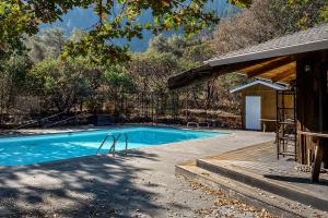 a swimming pool in front of a house at The Merryman Cabin in Hawkins Bar