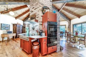 a kitchen with red cabinets and a brick wall at The Merryman Cabin in Hawkins Bar