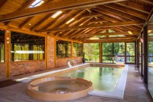 uma piscina interior com uma banheira de hidromassagem numa casa em Vila Maja em Brestovac