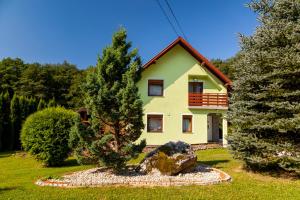 une maison jaune avec un arbre devant elle dans l'établissement Vila Maja, à Brestovac