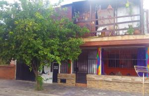 un edificio colorido con un árbol delante en Casita del arbol Hostel en San Salvador de Jujuy