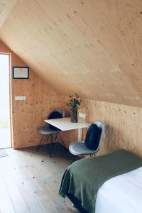 a room with a bed, chair, desk and a window at iStay Cottages in Sandgerði