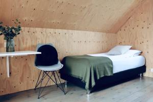 Sandgerði的住宿－愛思戴小屋酒店，一间卧室配有一张床、一张桌子和一把椅子