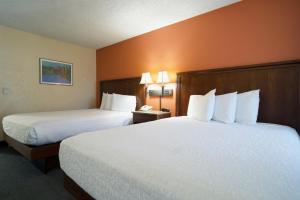 a hotel room with two beds with white pillows at Village Inn in Springfield