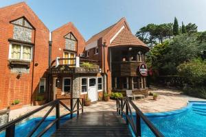 a building with a wooden walkway in front of a house at San Remo Villa Corral Apart in Carilo