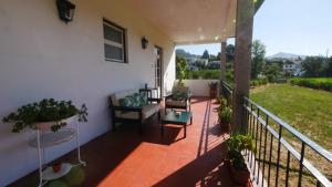 a balcony of a house with chairs and plants at Quinta do Arieiro in Arouca