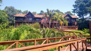 a house on a hill with a wooden bridge at San Remo Villa Corral Apart in Carilo