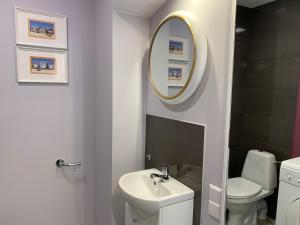a white bathroom with a sink and a mirror at Domek La Pergola in Łeba +33 photos