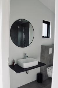 a bathroom with a sink, mirror, and bathtub at iStay Cottages in Sandgerði