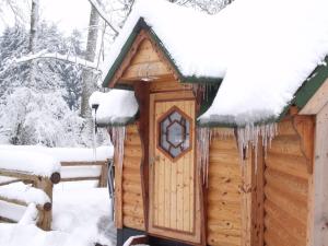 una cabaña cubierta de nieve con carámbanos. en Le Domaine du Châtelet, en Ferdrupt