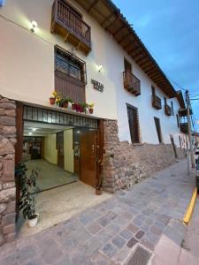 un gran edificio blanco con un patio delante de él en Hostal Saphi - Excelente ubicación, en Cusco