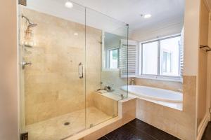 un bagno con vasca e doccia in vetro di Barham Boutique Townhouse a Los Angeles