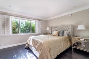 una camera da letto bianca con un letto e due finestre di Barham Boutique Townhouse a Los Angeles