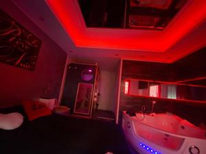 薩爾格米納的住宿－Le Rêve d'une Nuit suite Amour，天花板上设有红灯和浴缸的房间
