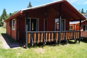 una pequeña casa de madera con un porche en un campo en Cabañas LLicaldad, en Castro