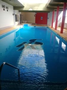 - une piscine d'eau bleue dans un bâtiment dans l'établissement San Remo World Hotel, à San Clemente del Tuyú
