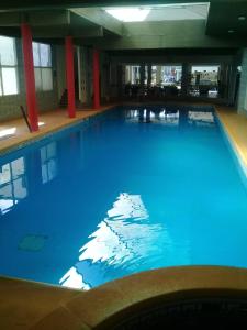 uma grande piscina com água azul num edifício em San Remo World Hotel em San Clemente del Tuyú