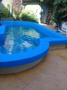 una piscina azul en un patio en San Remo World Hotel en San Clemente del Tuyú