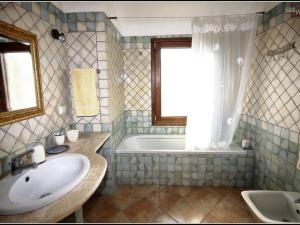 a bathroom with a sink and a tub and a window at La Sima villa con piscina vista mare San Pantaleo Sardegna in San Pantaleo +60 photos