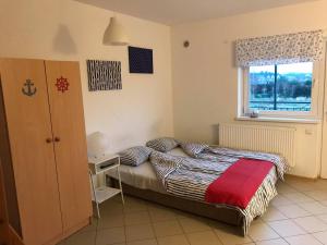 a small bedroom with a bed and a window at Relaks Rusinowo in Rusinowo