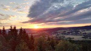 einen Sonnenuntergang über einer kleinen Stadt in den Bergen in der Unterkunft Naturresort Bieleboh in Beiersdorf