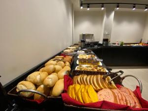 a buffet line with different types of bread and pastries at Lapônia Hotel Gramado in Gramado