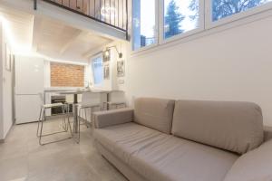 a living room with a couch and a kitchen at Loft-Relax in Bologna