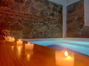 a room with candles and a tub with a stone wall at Villino Eleonora in Parghelia