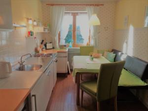 een keuken met een tafel en een wastafel en een tafel en stoelen bij Ferienwohnungen Lackner - Chiemgau Karte in Inzell +23 foto's