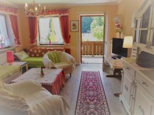 een woonkamer met een bank en een tv bij Ferienwohnungen Lackner - Chiemgau Karte in Inzell