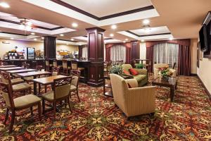 a restaurant with tables and chairs and a bar at Holiday Inn Express Hotel & Suites Henderson - Traffic Star, an IHG Hotel in Henderson