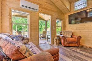 una sala de estar con sofá y sillas en una cabaña en Quaint Mtn Cabin Tiny Living Near Big Adventure en Brevard