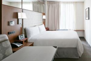 ニューヨークにあるClub Quarters Hotel Grand Central, New Yorkの大きなベッドと椅子のあるホテルの部屋