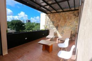 een balkon met witte stoelen, een tafel en een raam bij Casa Verano - 2 Hab 4 Baños Jacuzzi Rooftop A/C in Mérida