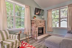 uma sala de estar com lareira e 2 janelas em Serene Poconos Cabin with Fire Pit and Creek Access! em Brodheadsville