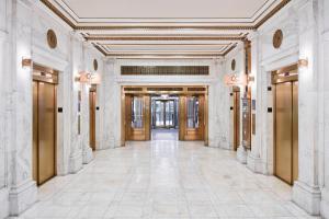 un pasillo vacío de un edificio con puertas y azulejos en Club Quarters Hotel Wacker at Michigan, Chicago, en Chicago