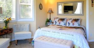 a bedroom with a bed and a chair and a mirror at Bella Vista Bed and Breakfast in Coloma